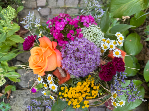 Bunte Blumenstrauß mit Rosen, Astern und verschiedenen Wildblumen.